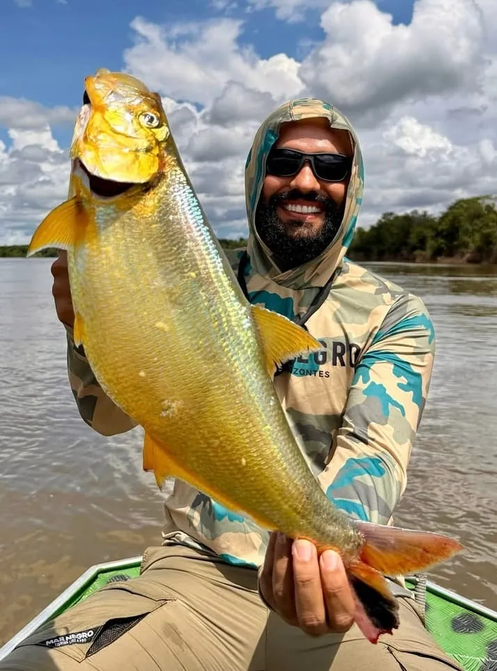 Pescador de capuz segura uma dourada