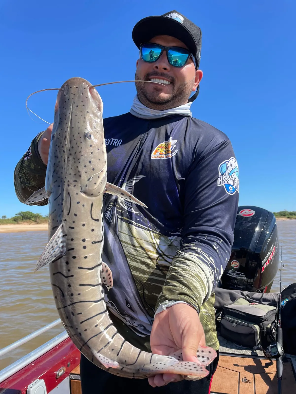 Pescador segura uma cachara na vertical