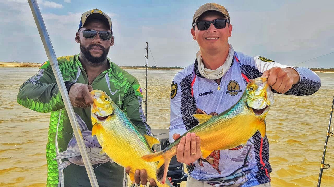 Dois pescadores seguram douradas