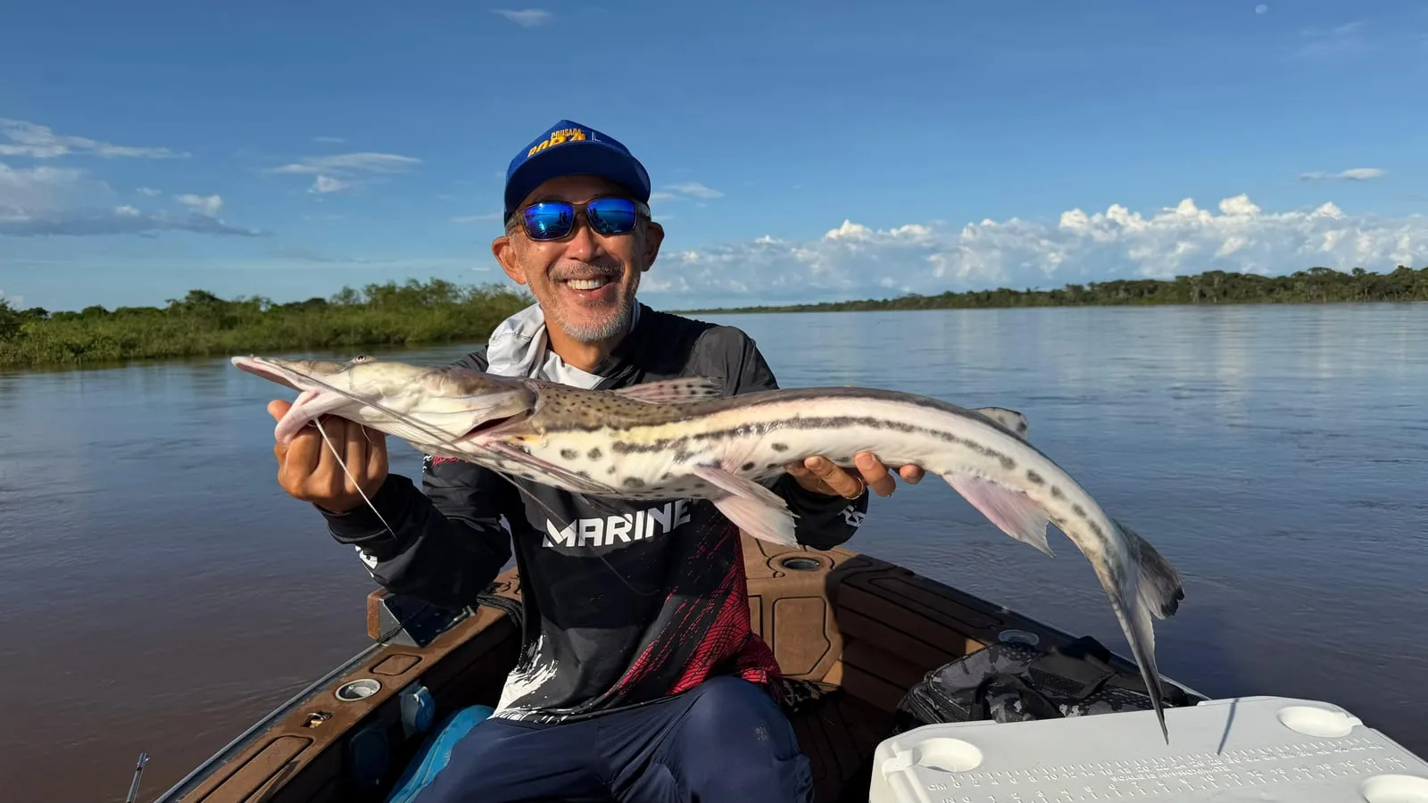 Pescador num barco segura uma cachara