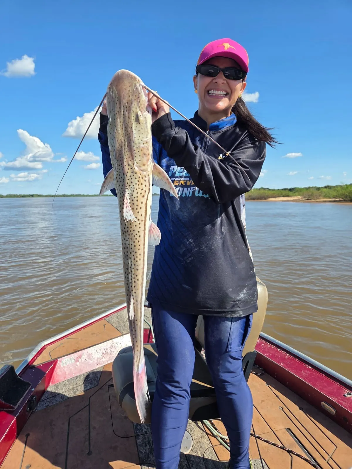 Pescadora num barco ergue uma cachara