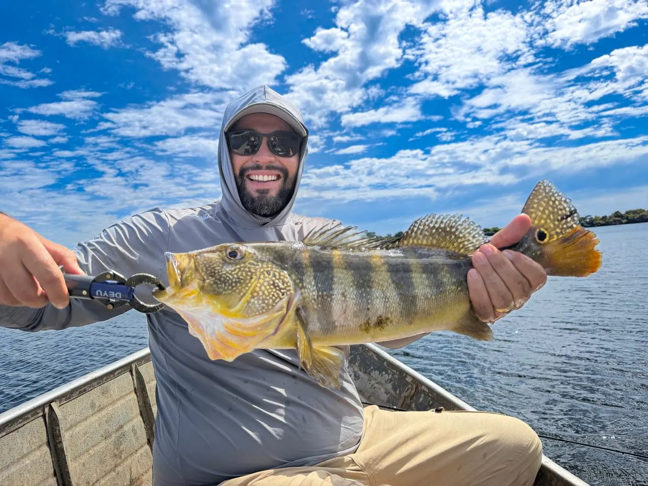 Pescador de capuz segura um tucunaré