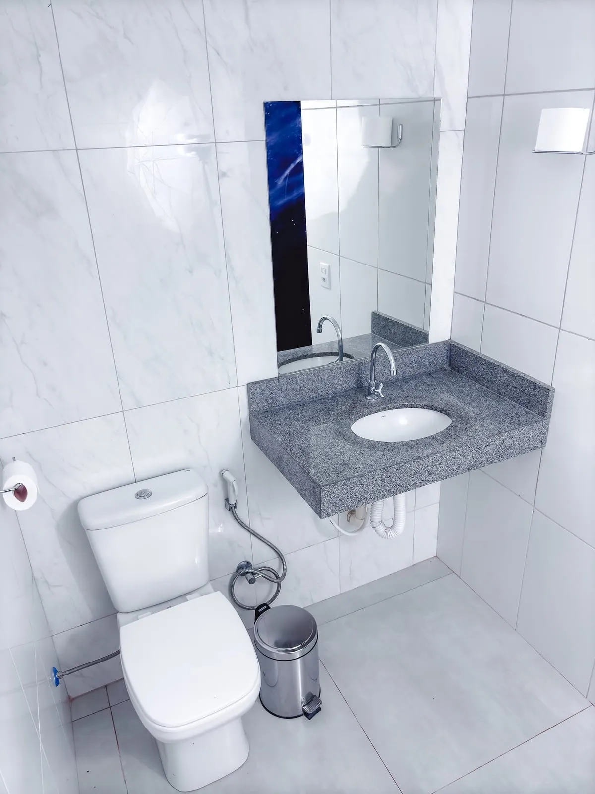 Banheiro privativo com pia de granito e vaso sanitário