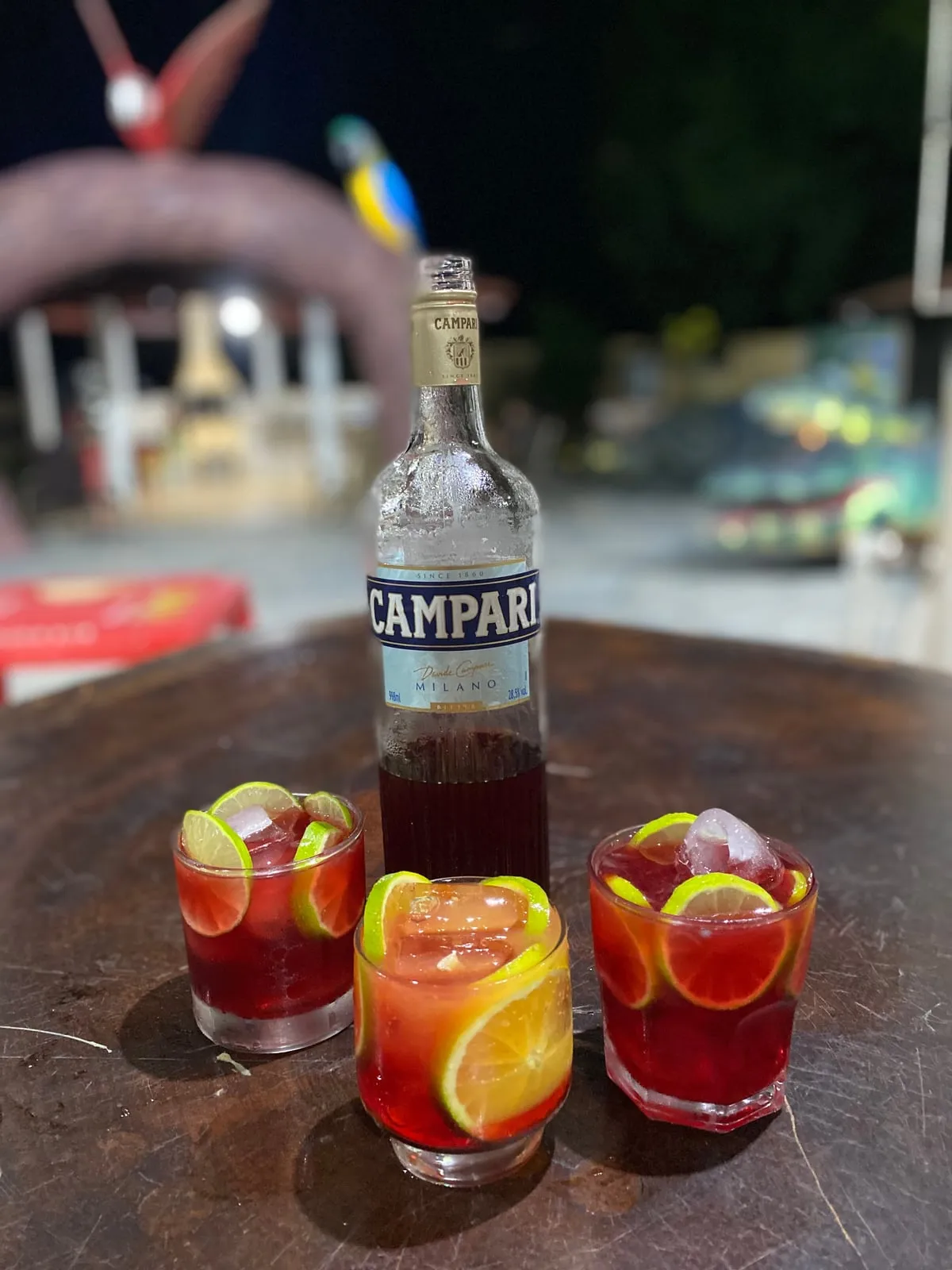 Garrafa de Campari e copos com laranja