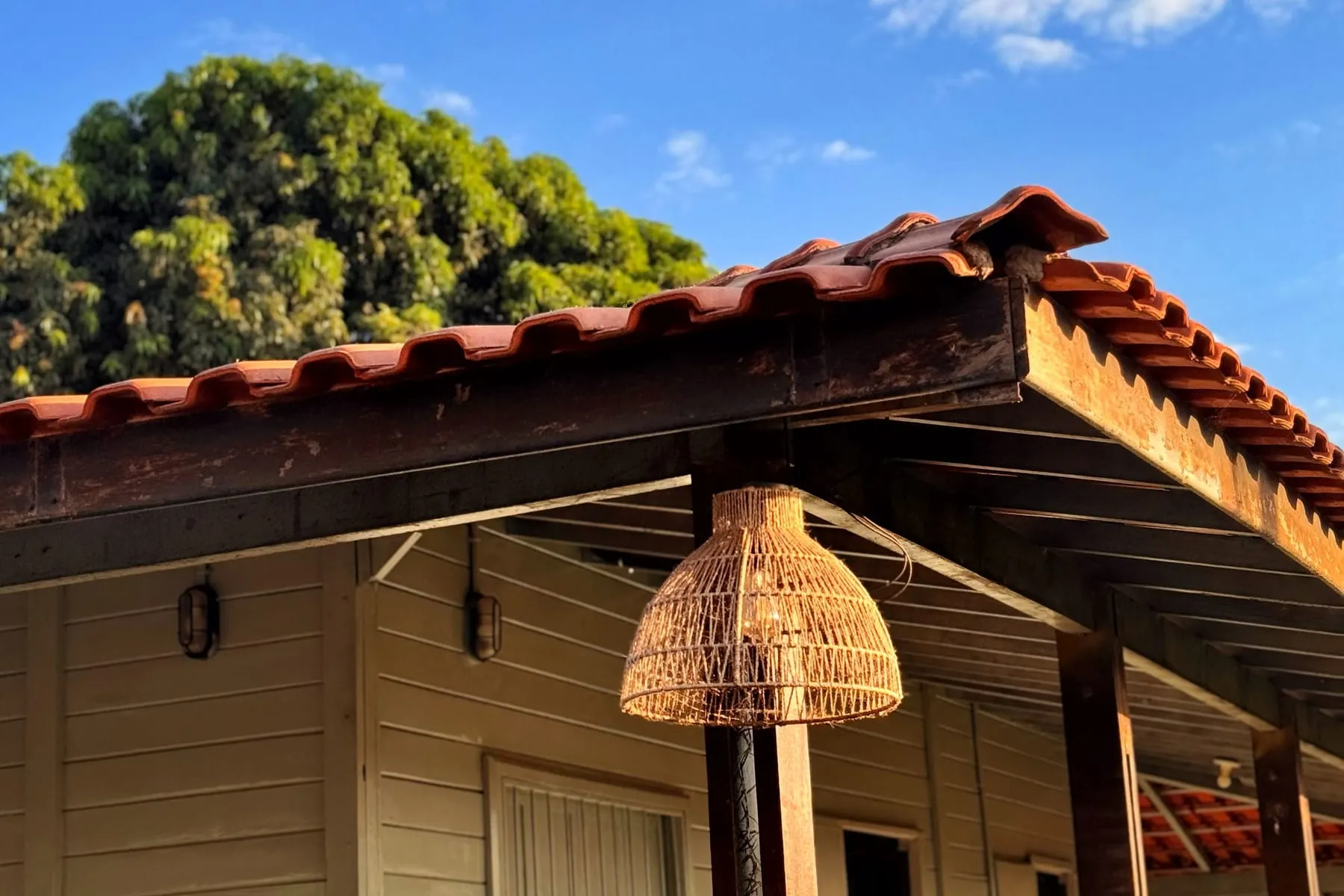 Chalé de madeira com telhado de telha e luminária de palha