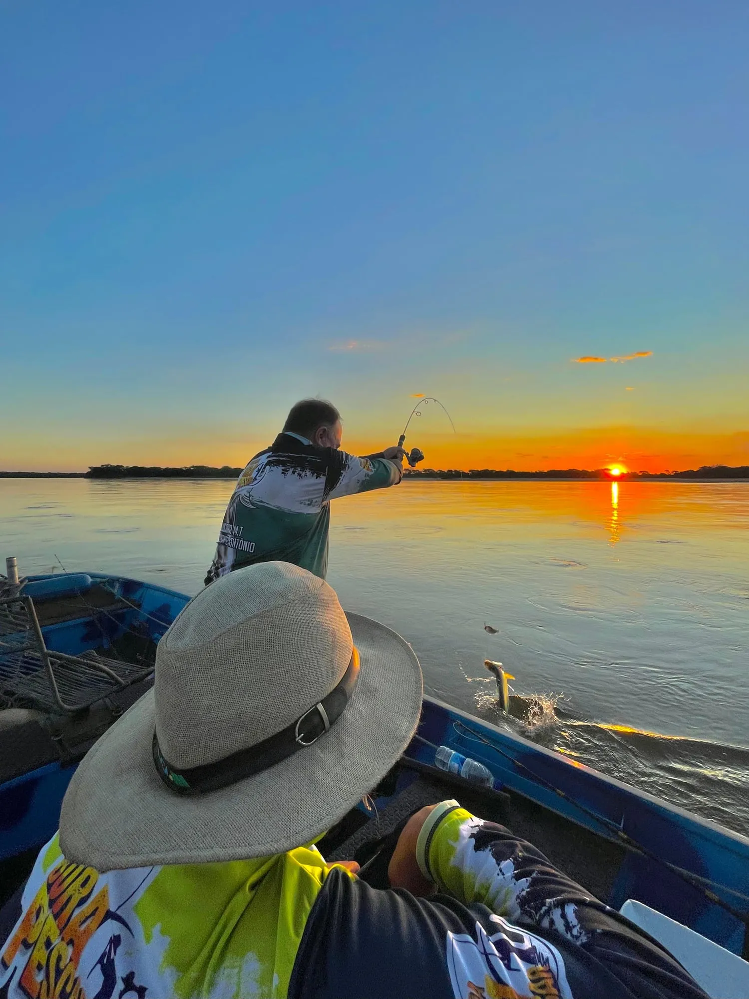 Pescador arremessa do barco no Rio Araguaia ao pôr do sol
