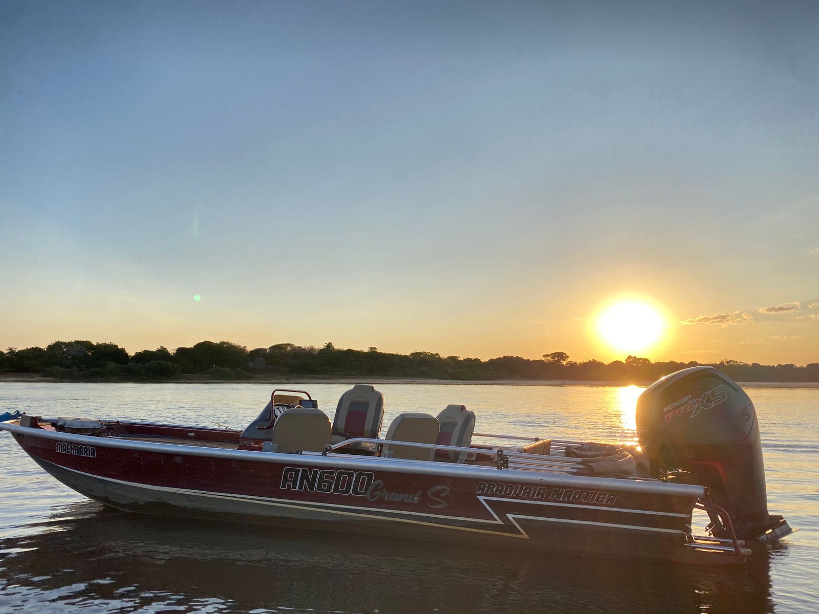Barco de pesca no Rio Araguaia com o sol se pondo ao fundo