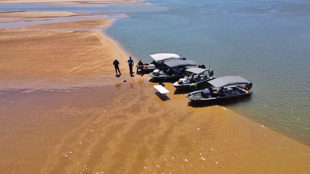 Vista aérea de barcos de pesca parados numa praia de areia no Rio Araguaia