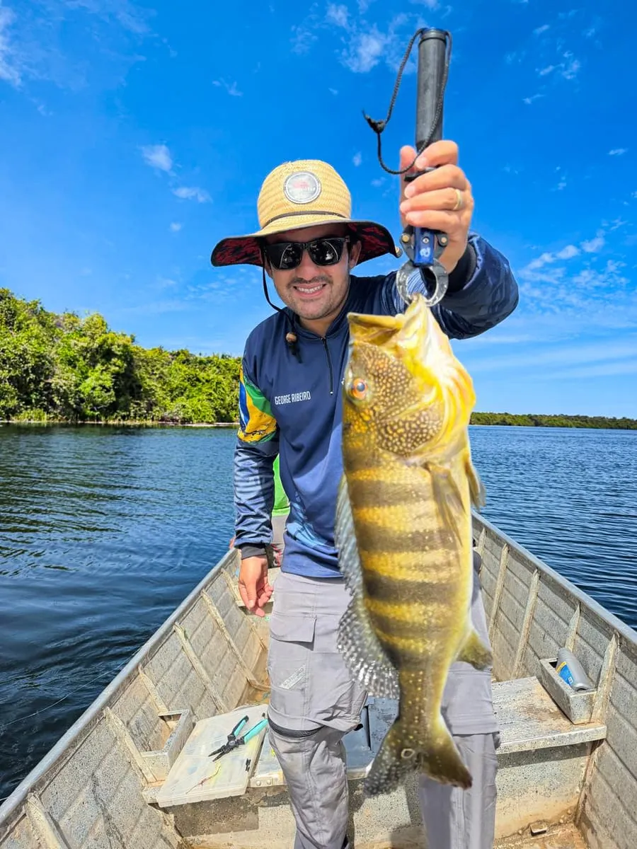 Pescador com um tucunaré no Rio Araguaia